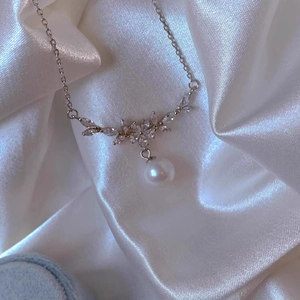 Detailansicht einer silbernen Blumenkette mit Marquise-Kristallen und einer Perle