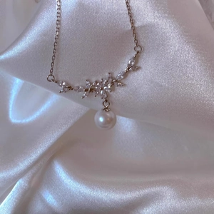 Detail von Silberanhänger mit Marquise-Kristallen und runder weißer Perle auf Seidenstoff