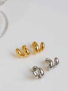 Dettaglio di orecchini a doppio cerchio intrecciati in finitura oro e argento