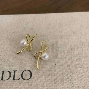 Boucles d'oreilles nœud doré élégantes avec perle sur carte de présentation