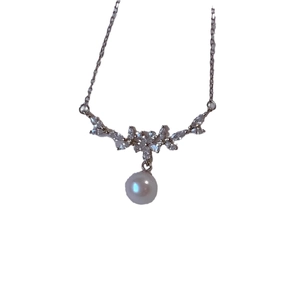Elegante Perlenhalskette mit silberner Kette und Zirkonia-Blütenanhänger auf weißem Hintergrund