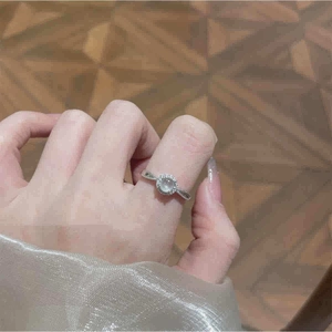 Close-up of cat eye stone ring with zircon halo and silver hollow twisted band