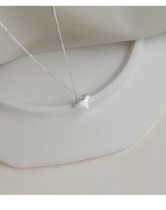 Detail view of silver heart pendant necklace with matte sandblasted finish and beaded chain