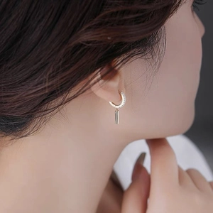 Elegant C-shaped gold hoop earrings with white zircons and cylindrical metal pendant