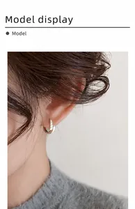 Primo piano di eleganti orecchini a cerchio geometrici in argento con pavé di zirconi