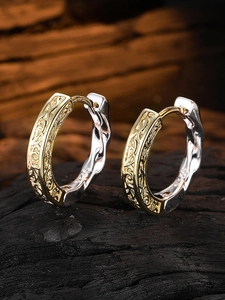 Detail of S925 sterling silver earring with retro textured hollow design and bicolor finish