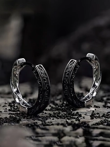 Macro detail of dark oxidized hoop earrings featuring intricate vintage spiral textures
