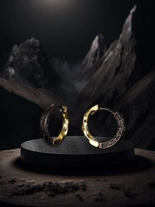 Detail of vintage black and gold contrast hoop earrings with textured floral carvings