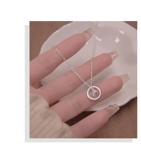 Nahaufnahme einer silbernen Orchideen-Halskette in der Hand mit einem minimalistischen Design