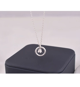 Makroaufnahme von Maiglöckchen-Anhänger in einem silbernen Ring an feiner Kette