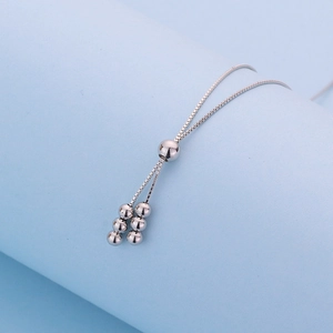 Macro shot of silver box chain with adjustable slider bead and small round bead details