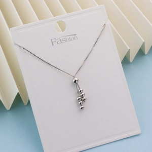 Detailed macro view of silver box chain necklace with elegant metal bead tassel pendant