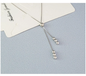 Detail of adjustable silver box chain necklace with sleek bead fringe and sliding toggle