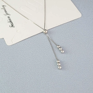 Minimalist silver bead tassel necklace with adjustable sliding buckle on card