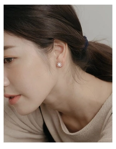 Close-up of minimalist silver clover stud earring worn by a woman for a stylish look