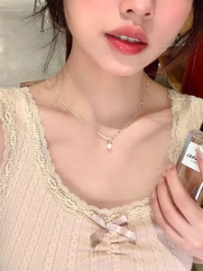 Detailed view of silver-tone patchwork necklace with crystal pendant on collarbone