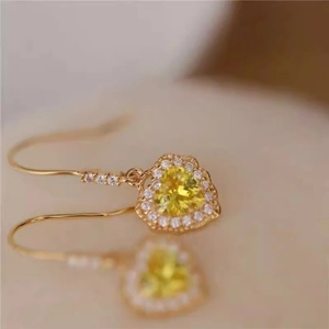 Macro detail of French vintage heart earring with yellow gemstone and pavé zircon border