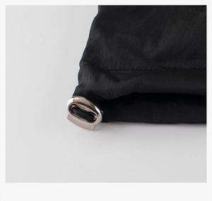 Détail du cordon de serrage élastique et du loquet en métal sur veste noire pour enfant