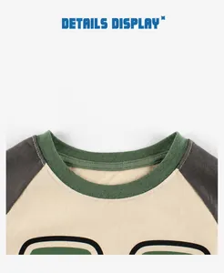Detail of kids' raglan tee showing green ribbed neckline and grey long sleeves