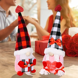 Valentinstag Gnome Plüschdeko mit roten Herzen und Karohüten auf Holztisch