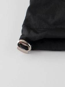 Détail de veste à capuche pour enfant avec bloqueur de cordon argenté et tissu noir