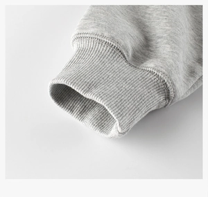Close-up of grey ribbed cuffs on kids sweatshirt showing high-quality cotton texture
