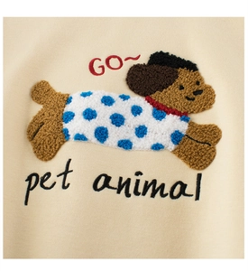Detail of chenille puppy embroidery on a beige sweatshirt with a soft texture