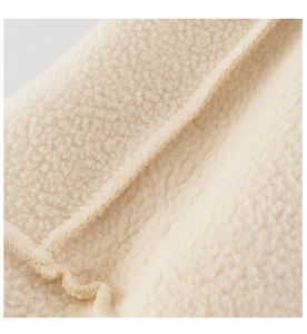 Detailed macro view of premium cream fleece fabric showing thick texture and soft sewing finish