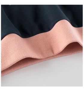 Close-up of pink ribbed cuffs and dark blue fleece fabric stitching on kids hoodie