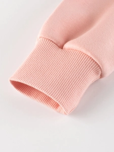 Close-up of pink children's sweatshirt showing ribbed cuffs and soft cotton fabric
