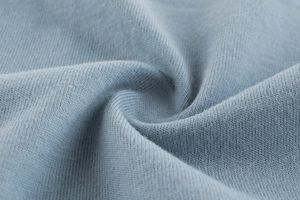 Détail macro du tissu en jersey de coton bleu clair doux pour tee-shirt enfant
