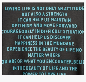Detail of inspirational blue screen print text on black fleece sweatshirt fabric