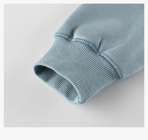 Detailed close-up of ribbed cuffs on a grey-blue sweatshirt with premium stitching