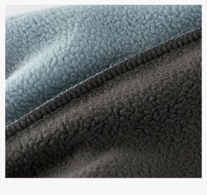 Detailed close-up of premium blue and gray fleece fabric stitching for warmth