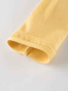 Detail of a bright yellow long sleeve t-shirt with high-quality stitching on the cuffs