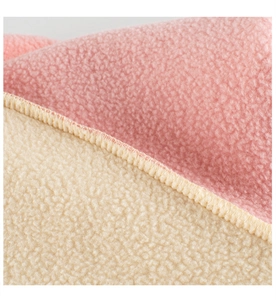 Close-up of pink and beige double-sided fleece fabric with high-quality overlock stitching