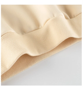 Macro shot of the ribbed cuff detail on a cream fleece sweatshirt for kids