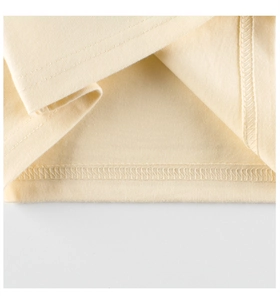 Dettaglio ravvicinato dell'orlo in maglia color crema con cucitura a doppio ago fine