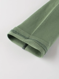 Close-up of sleeve cuffs and stitching on green long-sleeve raglan T-shirt for kids