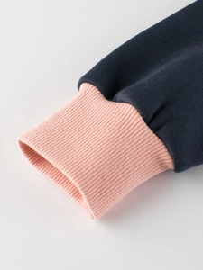 Close-up of kids' navy cotton sweatshirt sleeve with pink ribbed cuffs and soft fleece lining