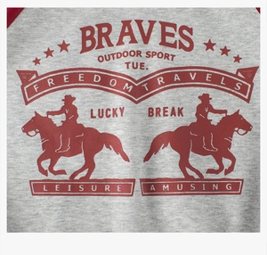 Close-up of gray raglan sweatshirt with red vintage cowboy and letter print design