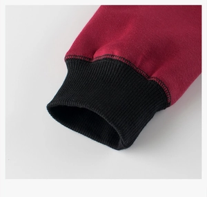 Detail of burgundy knitted sleeve with black ribbed elastic cuff for kids' sweatshirts