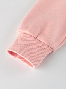 Close-up of pink children fleece sweatshirt showing ribbed cuffs and soft cotton fabric