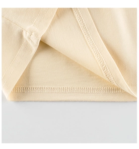 Detail shot of beige cotton fabric showing high-quality double stitching on the hem