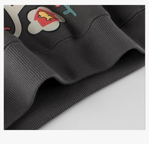 Detalle de sudadera gris oscuro con dobladillo acanalado y estampado gráfico floral