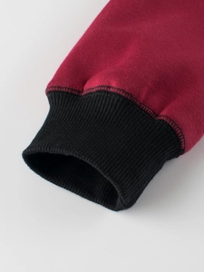 Close-up of burgundy fleece sweatshirt with black ribbed cuffs and premium stitching