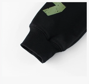 Close-up of black sweatshirt ribbed cuffs with green distressed graphic print detail