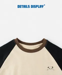 Close-up of raglan sleeve crewneck with panda print and brown ribbed collar detailing
