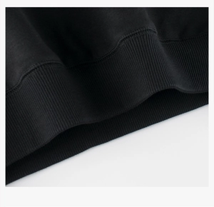 Macro shot of black fleece sweatshirt hem showing ribbed knit cuffs and double stitching