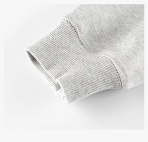 Detailed macro shot of grey ribbed cuffs and soft fleece lining on children's sweatshirt